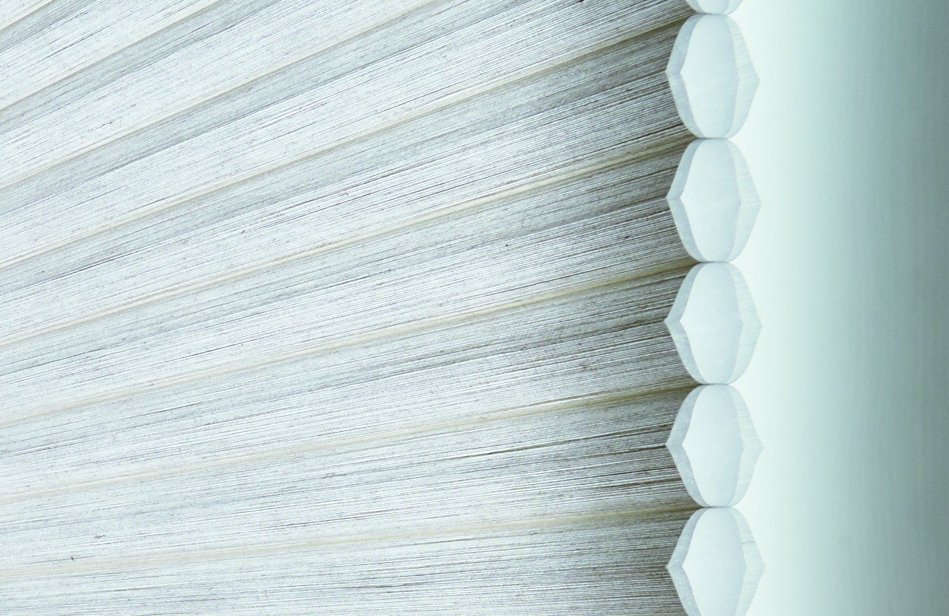 Close-up of the edge of a honeycomb shade, showing the row of hexagon-shaped air pockets