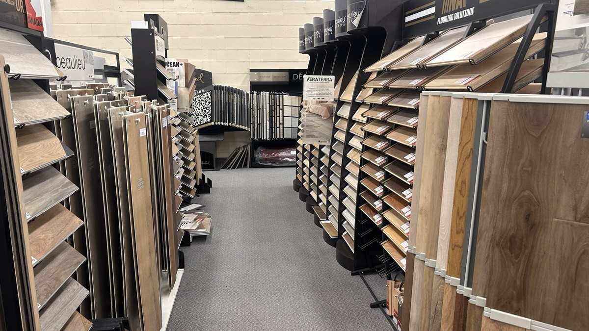 An aisle of hardwood and vinyl plank samples in the Kingsway showroom